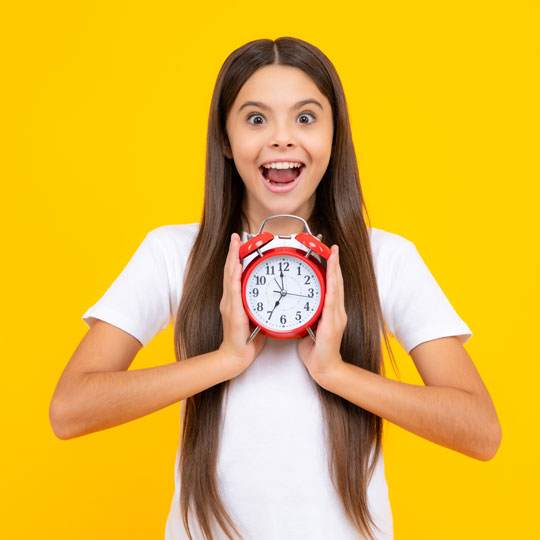 Teen holding a clock and smiling
